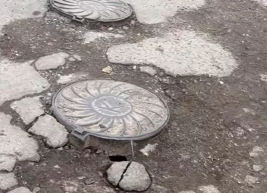 “Поўны ігнор двара”. Жыхары дома па вуліцы Брыкеля скардзяцца на разбітую дарогу ў расколінах, дзірках і ямах