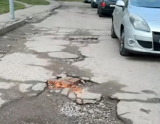 “Поўны ігнор двара”. Жыхары дома па вуліцы Брыкеля скардзяцца на разбітую дарогу ў расколінах, дзірках і ямах