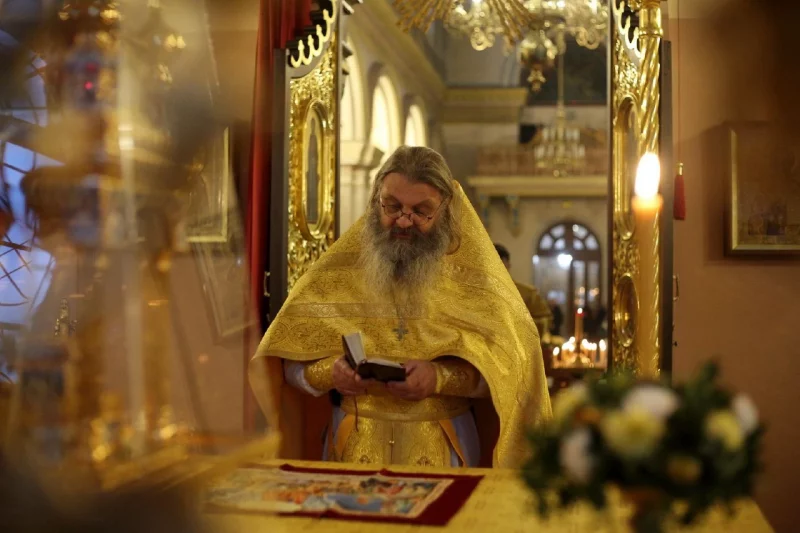 Расійскі свяшчэннік Сергій Баранаў чытае кнігу ў багата ўпрыгожаным Гродненскім саборы.