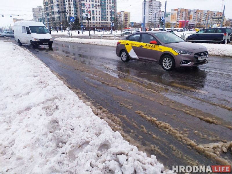Па заснежанай вуліцы з бруднай слотай праязджаюць машыны і зрэдку таксі, а на заднім плане вымалёўваюцца жылыя дамы. Гэта сцэна, якая адлюстроўвае кіпучую энергію навагодняй ночы.