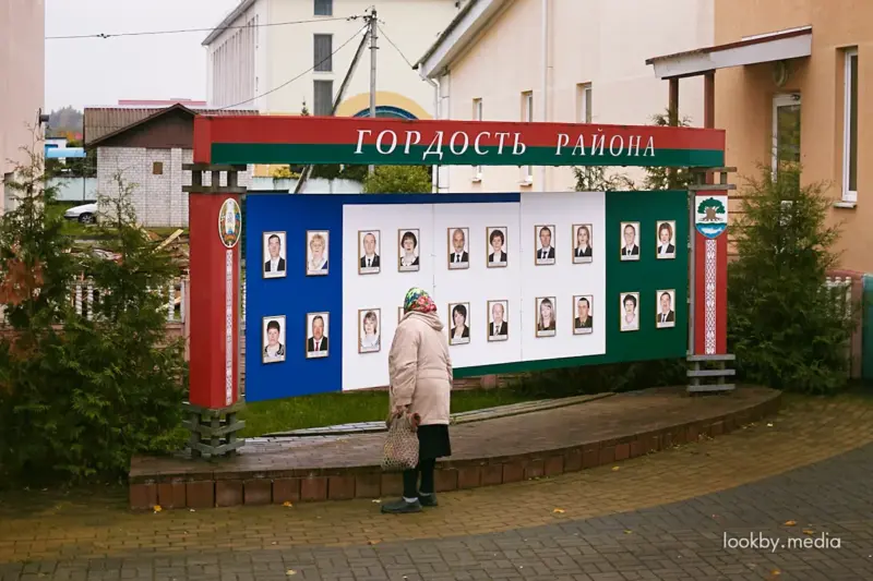 Жанчына глядзіць на дошку гонару "Гонар раёна" недзе ў Астравецкім раёне © LookByMedia